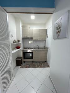 een keuken met witte kasten en een fornuis met oven bij La casa di Dafne in Messina