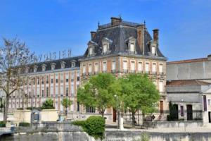 a large building in front of a river at Maison Meire Studios in Cognac