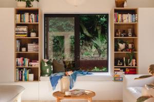 una ventana en una sala de estar con un estante de libros en Urban oasis with sauna en Wellington