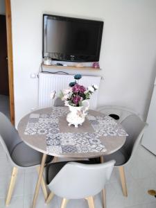 a dining room table with a vase of flowers on it at ΑLEXANDRAS HOUSE in Preveza