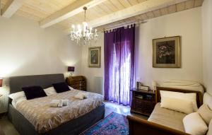 a bedroom with a bed and a chandelier at Al Battistero Luxury Suite in Ravenna