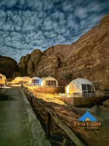 um grupo de cúpulas em frente a uma montanha em Rum Oasis Luxury Camp em Wadi Rum
