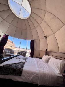 um quarto com uma cama e cadeiras numa tenda em Rum Oasis Luxury Camp em Wadi Rum