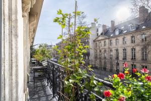 a balcony with flowers in front of a building at Deluxe Paris St Germain Suite in Paris