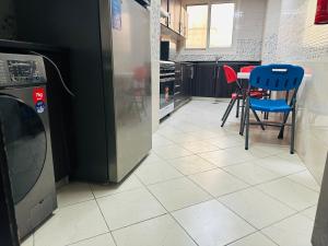 a kitchen with a refrigerator and a table and chairs at Private Room in beautiful Appartment in Dubai