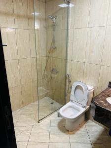 a bathroom with a toilet and a glass shower at Private Room in beautiful Appartment in Dubai