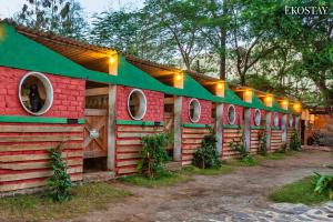 a row of wooden houses with lights on them at EKO STAY - The Ranch Villa in Deolāli