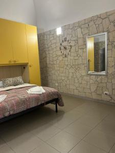 een slaapkamer met een bed en een stenen muur bij Monolocale Elena in Vieste