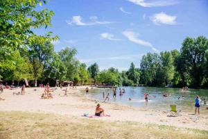 a group of people on a beach near a body of water at Maison du 12ème siècle in Saint-Privat-des-Prés