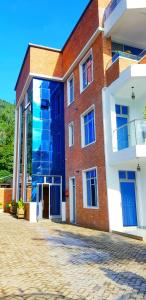 un bâtiment en briques avec des portes bleues sur son côté dans l'établissement Kivu Summer Hotel, à Rubavu