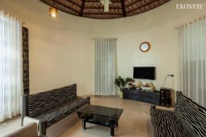 a living room with a couch and a tv at EKO STAY - The Ranch Villa in Deolāli