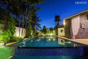 a swimming pool in a backyard at night at EKO STAY - The Ranch Villa in Deolāli