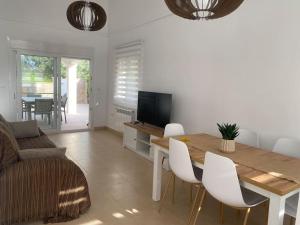 a living room with a table and white chairs at Villa Jacaranda in Torre-Pacheco