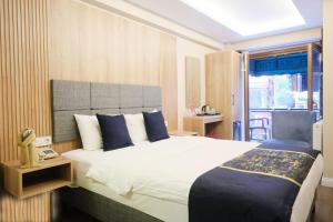 una camera da letto con un grande letto bianco con cuscini blu di Hotel Martin a Istanbul