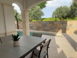 a patio with a table and chairs and a pool at Villa Jacaranda in Torre-Pacheco
