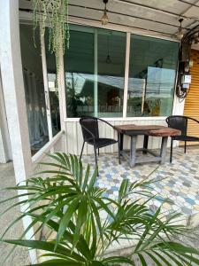 un patio con mesa y sillas en un porche en Jidjai hostel en Chiang Rai