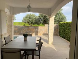 a dining table and chairs on a patio with an archway at Villa Jacaranda in Torre-Pacheco