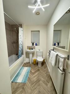 a bathroom with a sink and a toilet and a bath tub at Beautiful Home in Wolverhampton! in Wolverhampton