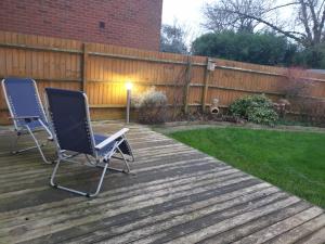 two chairs sitting on a deck in a backyard at Beautiful Home in Wolverhampton! in Wolverhampton