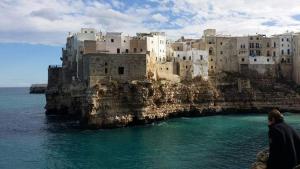 una persona parada en un acantilado cerca del océano en Antica Dimora Lombardi 2, en Bari