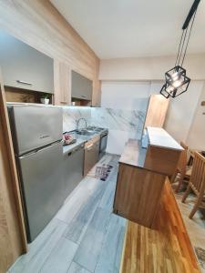 a kitchen with a stainless steel refrigerator and a counter at Lux Apartment Dolce Casa Skopje Karpos IV in Dolno Nerezi