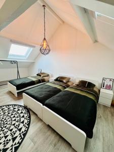 - 2 lits dans une chambre mansardée avec une lucarne dans l'établissement Stylish Home near Maastricht Alicias house, à Lanaken