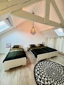 - 2 lits dans une chambre mansardée avec lucarnes dans l'établissement Stylish Home near Maastricht Alicias house, à Lanaken