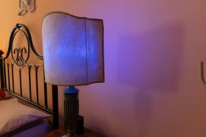 a lamp in a bedroom next to a bed at Rachele’s charming house in the heart of Rome in Rome