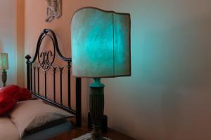 a lamp with a green lamp shade next to a bed at Rachele’s charming house in the heart of Rome in Rome