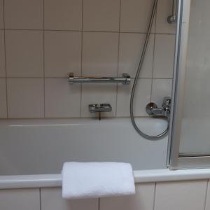 y baño con ducha y toalla blanca. en FeWo Bader, en Ohlstadt