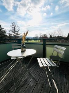 une table blanche et deux chaises sur une terrasse dans l'établissement Wohlfühl-Apartment Mareiki*Balkon*Stellplatz*WIFI*, à Erfurt