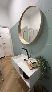 een badkamer met een witte wastafel en een spiegel bij La Casetta 2,0 in Noli