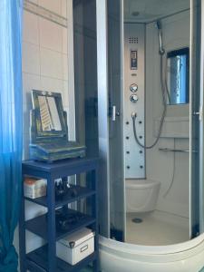 a bathroom with a shower with a blue table and a toilet at Draisina Bike ROOM in Oleggio Castello