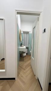 een badkamer met een wastafel, een toilet en een spiegel bij La Casetta 2,0 in Noli