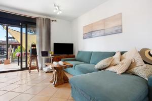 Una sala de estar con un sofá azul y un televisor. en Amadeus, en La Oliva