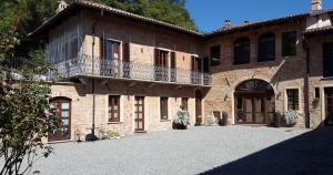 a large brick building with a balcony on it at Dimora Cortese in Castagnole Lanze