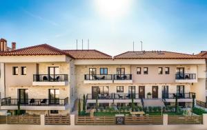 a large building with balconies and tables in front of it at Mpikas Holidays in Ierissos