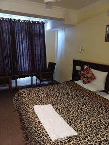 a hotel room with a bed and a piano at Hotel Town Centre , Srinagar in Srinagar