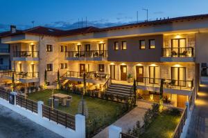 un edificio de apartamentos con patio por la noche en Mpikas Holidays, en Ierissos