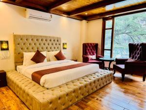 a bedroom with a large bed with a large tufted headboard at The Kasol Parvati View by - ASIA HOLIDAYS in Kasol