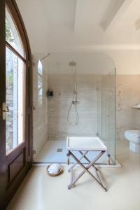 a bathroom with a glass shower and a table at Villa Paolo Lemon Tree in Portovenere