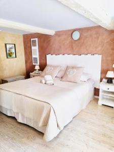 ロルグにあるLa Bastide Du Vieux Fourのベッドルーム1室(大型ベッド1台、白いシーツ、枕付)