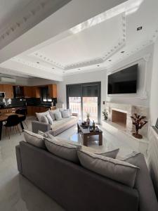 een woonkamer met een bank en een open haard bij KONTIS' Deluxe furnished apartment in Loutraki