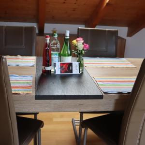 Una mesa con dos botellas de soda y flores. en FeWo Bader, en Ohlstadt