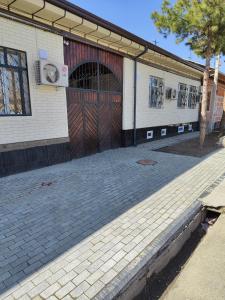 a building with a large door and a brick driveway at MiCasa Family Guesthouse in Tashkent