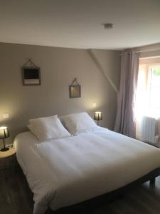 a bedroom with a large white bed with a window at Le Trèfle à Quatre Feuilles in Siorac-en-Périgord