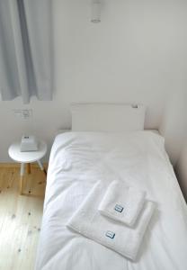 a white bed with two white towels on it at RESET Mielno in Mielno