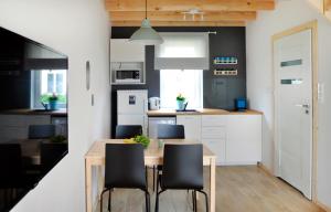 a kitchen with a wooden table and black chairs at RESET Mielno in Mielno