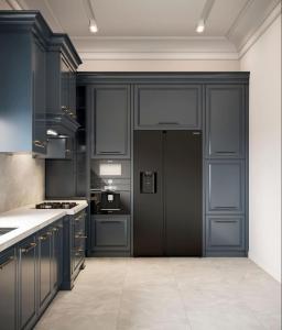 a kitchen with black cabinets and a refrigerator at Vip Apartment Baku palace in Baku