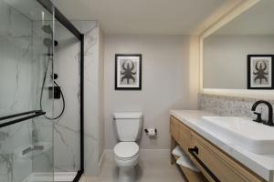 y baño con aseo, lavabo y ducha. en Hotel Rumbao, a Tribute Portfolio Hotel by Marriott, en San Juan